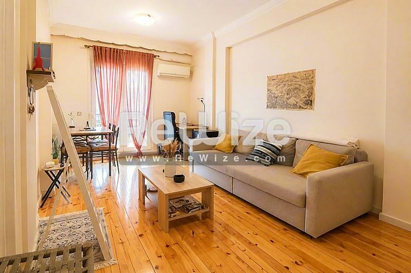 Φωτεινό σαλόνι διαμερίσματος στη Χαλκιδική με ξύλινα δάπεδα και άνετη διακόσμηση.