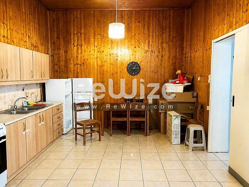 Ξύλινη κουζίνα σε μονοκατοικία προς πώληση στη Χαλκιδική με τραπεζαρία και συσκευές.