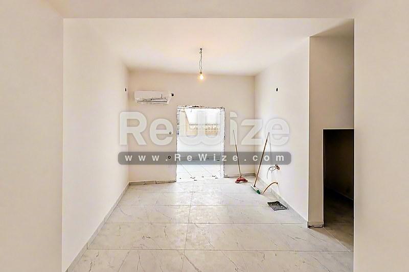 Φωτεινό και просторό σαλόνι στούντιο στη Χαλκιδική με πλακάκια και φυσικό φως από μεγάλα παράθυρα.