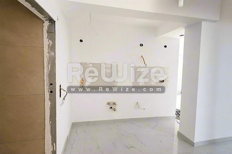 Χώρος αποθήκευσης studio διαμερίσματος υπό ανακαίνιση στην Χαλκιδική με λευκούς τοίχους.