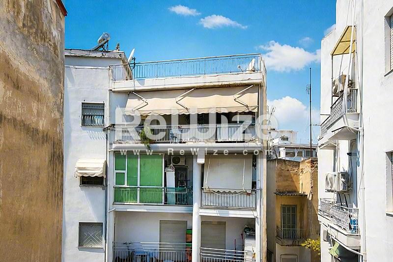 Πρόσοψη διαμερίσματος στη Χαλκιδική με πράσινα παραθυρόφυλλα και μπαλκόνια.