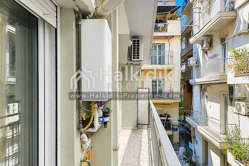 Στενό μπαλκόνι διαμερίσματος στη Χαλκιδική με θερμοσίφωνα και αστική θέα.