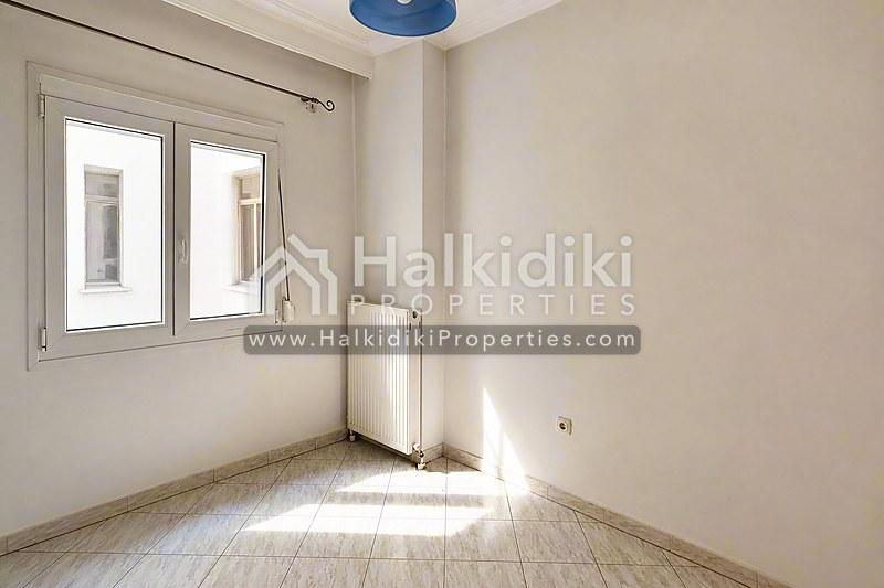 Φωτεινό υπνοδωμάτιο διαμερίσματος στη Χαλκιδική με φυσικό φως, ξύλινα δάπεδα και σύγχρονες ανέσεις.