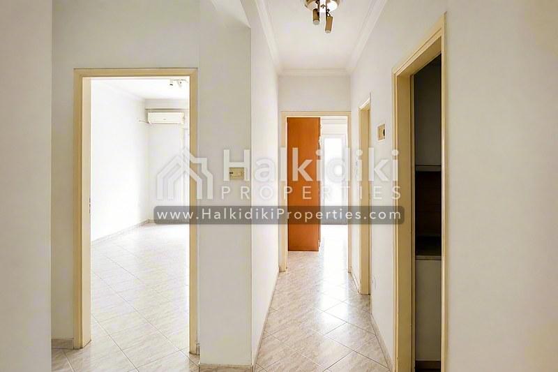 Φωτεινός διάδρομος διαμερίσματος στη Χαλκιδική με πόρτες ανοιχτού ξύλου και σύγχρονο δάπεδο.