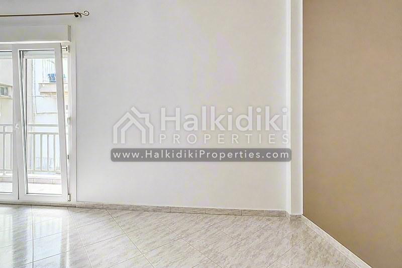 Φωτεινό σαλόνι διαμερίσματος στη Χαλκιδική με γυαλιστερό μάρμαρο και σύγχρονα έπιπλα.