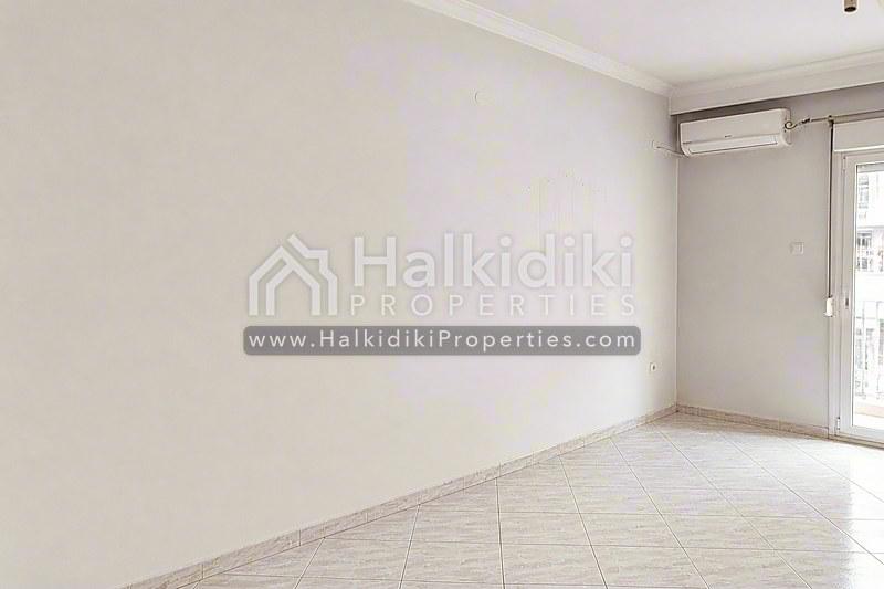 Φωτεινό και ευρύχωρο σαλόνι διαμερίσματος στη Χαλκιδική με πλακάκια και μοντέρνο μινιμαλιστικό σχεδιασμό.