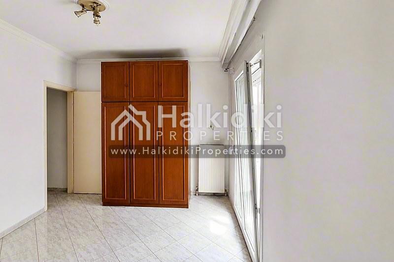 Ευρύχωρο αποθηκευτικό δωμάτιο σε διαμέρισμα της Χαλκιδικής με ξύλινες ντουλάπες και φυσικό φως.