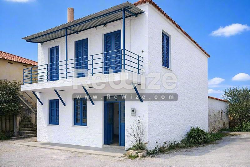 Σύγχρονη λευκή βίλα με μπλε παντζούρια και μπαλκόνι στη Χαλκιδική