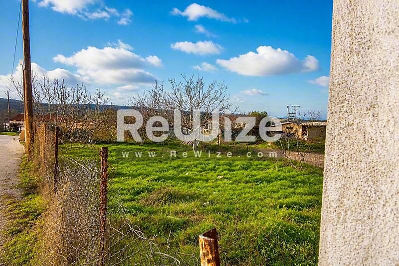 Ευρύχωρο οικόπεδο στη Χαλκιδική με πράσινα χωράφια και καθαρό ουρανό.