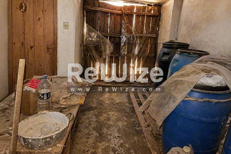 Αποθήκη του ακινήτου rw-7431 στη Χαλκιδική με βαρέλια, υλικά κατασκευής και εξοπλισμό.
