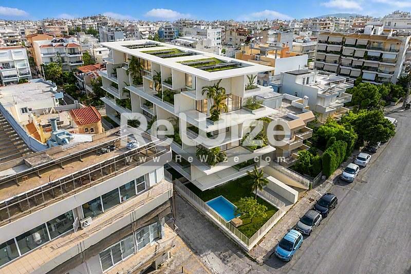Εναέρια άποψη μοντέρνου συγκροτήματος κατοικιών στη Χαλκιδική με διαβαθμισμένους πράσινους χώρους και πισίνα.