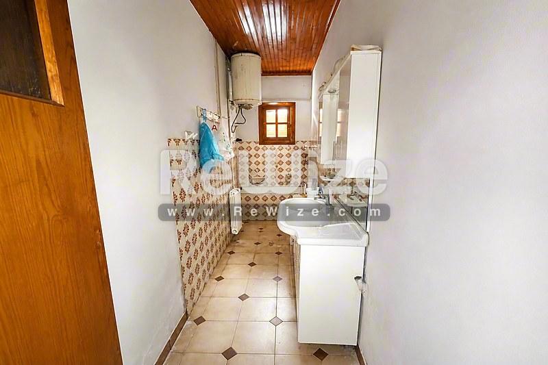 Ευρύχωρο μπάνιο στο ακίνητο Halkidiki rw-7461 με παραδοσιακά πλακάκια, διπλό νιπτήρα και φυσικό φωτισμό.