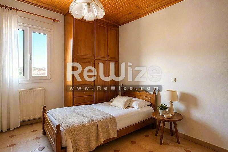 Ευρύχωρο υπνοδωμάτιο στη βίλα Halkidiki rw-7461 με ξύλινη ντουλάπα, πήλινα πατώματα και φυσικό φως.