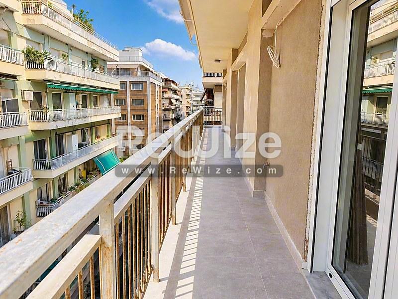 Ευρύχωρο μπαλκόνι του διαμερίσματος στη Χαλκιδική με ηλιόλουστη θέα στη γύρω κατοικημένη περιοχή.
