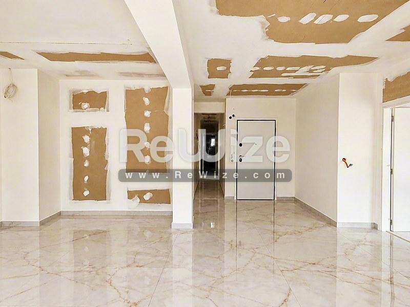 Ευρύχωρο σαλόνι με μαρμάρινο δάπεδο και ξύλινες λεπτομέρειες οροφής στο ακίνητο Χαλκιδικής rw-7523.
