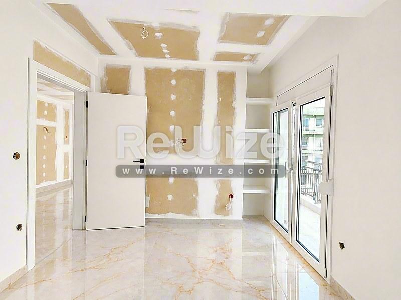 Σύγχρονο σαλόνι με μαρμάρινο δάπεδο και ενσωματωμένη αποθήκευση σε ακίνητο υπό κατασκευή στη Χαλκιδική.