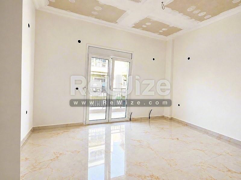Φωτεινό σαλόνι με μαρμάρινο δάπεδο και γυάλινες πόρτες μπαλκονιού σε ιδιοκτησία στη Χαλκιδική.