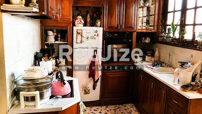 Συμπαγή κουζίνα στο διαμέρισμα rw-7568 Χαλκιδικής με ξύλινες ντουλάπες, κουζινέλη και vintage χαρακτήρα.