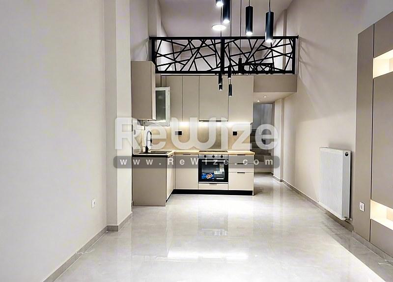 Σύγχρονη κουζίνα στο διαμέρισμα Halkidiki rw-7585 με λευκά ντουλάπια, ανοξείδωτες συσκευές και γυαλιστερά δάπεδα.
