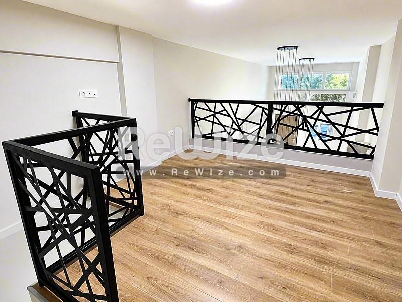 Σύγχρονη σκάλα με γεωμετρικές μαύρες κάγκελα σε ακίνητο Χαλκιδικής rw-7585.