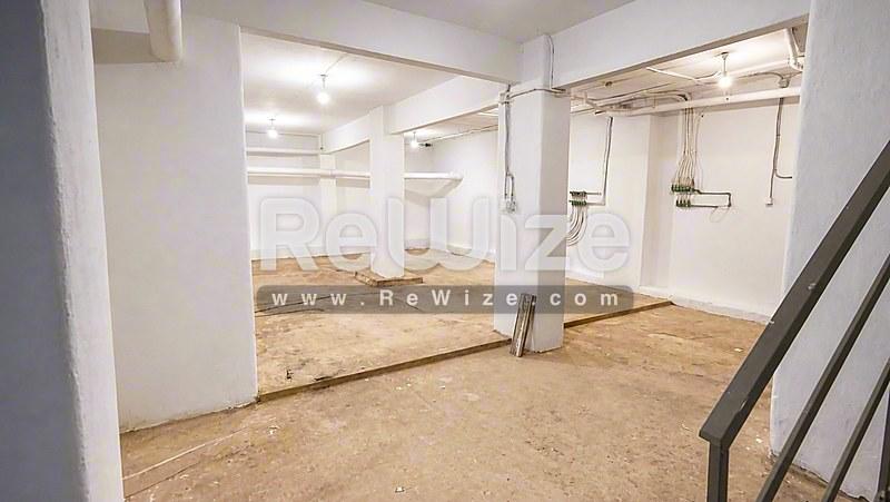 Ευρύχωρος χώρος αποθήκευσης του ακινήτου rw-7585 στη Χαλκιδική με σκυρόδεμα και φωτεινό φωτισμό.