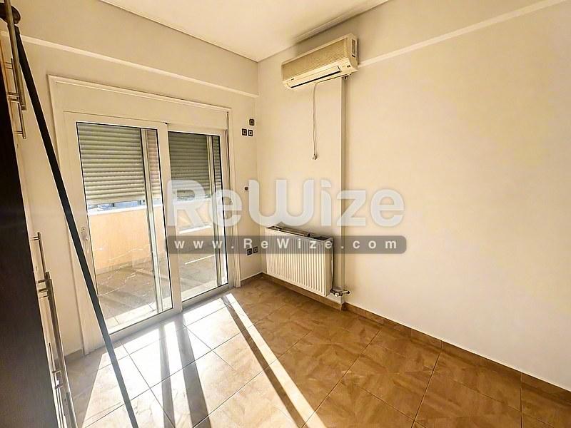 Φωτεινό υπνοδωμάτιο σε διαμέρισμα της Χαλκιδικής με ξύλινα δάπεδα, πρόσβαση σε μπαλκόνι και σύγχρονη θέρμανση.