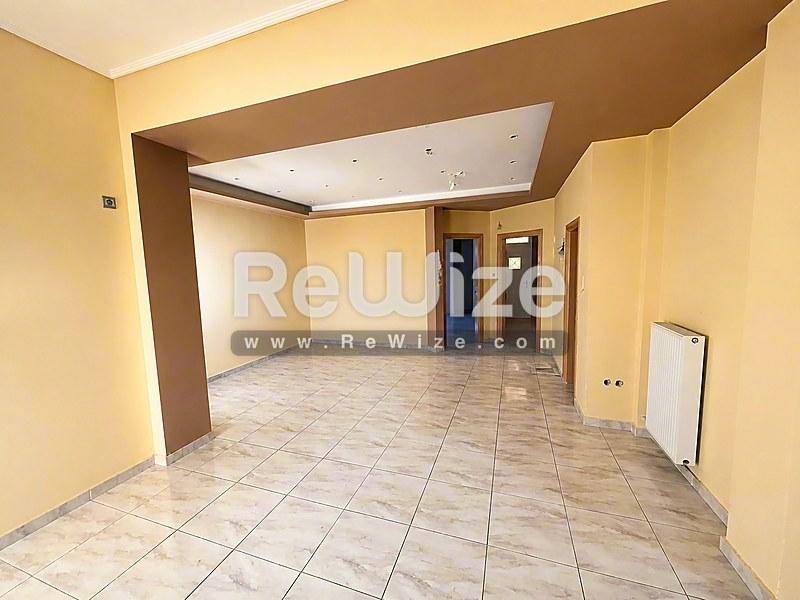 Ευρύχωρο σαλόνι του ακινήτου rw-7586 στη Χαλκιδική με πλακάκια και σύγχρονο σχεδιασμό οροφής.