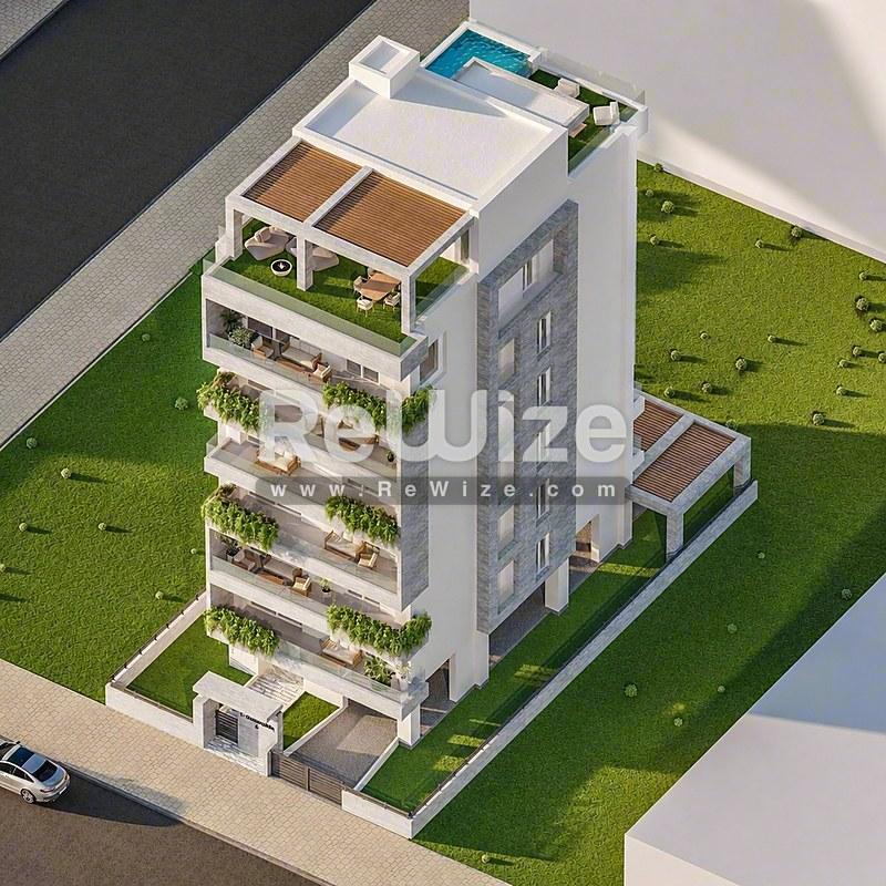 Αεροφωτογραφία σύγχρονου κτιρίου κατοικιών στη Χαλκιδική με πράσινες βεράντες και εξοπλισμό οροφής.