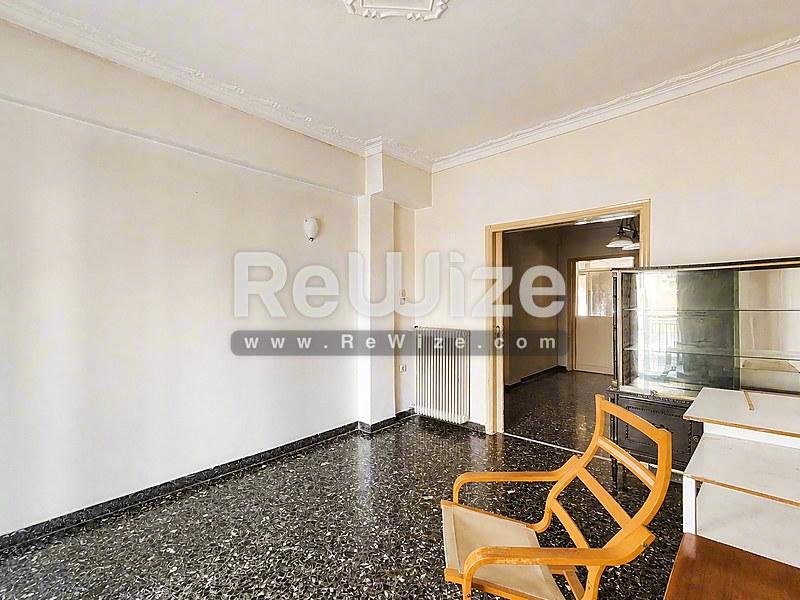 Ευρύχωρο σαλόνι σε διαμέρισμα Χαλκιδικής με δάπεδο τεράτσο και ξύλινη επίπλωση.