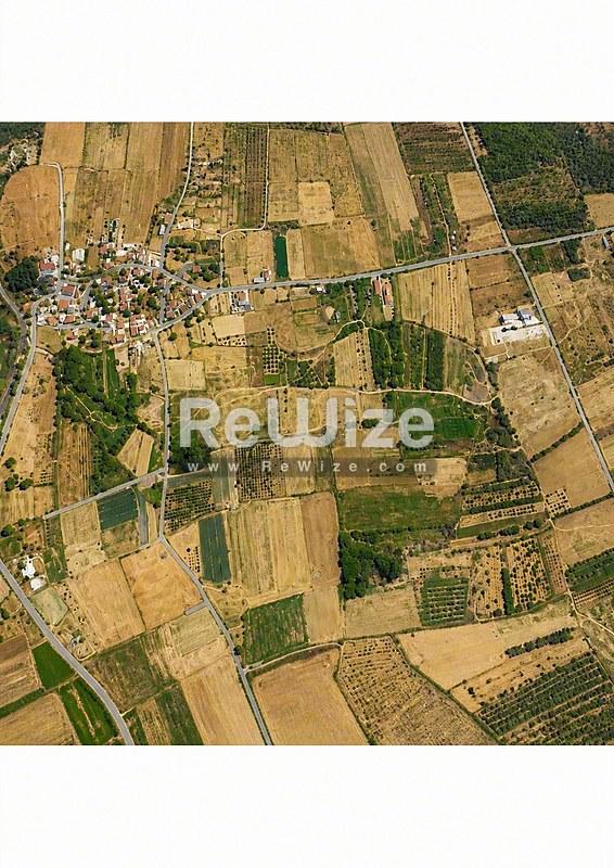 Εναέρια άποψη γεωργικής γης στη Χαλκιδική με χρωματιστά χωράφια και πράσινη βλάστηση.